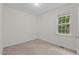 A cozy bedroom with carpet flooring and a window overlooking the backyard at 1027 Holden Rd, Youngsville, NC 27596
