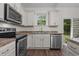 Bright kitchen featuring stainless steel appliances, granite countertops, and sleek white cabinetry at 1027 Holden Rd, Youngsville, NC 27596