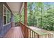 The home's wood porch is spacious with a lush, wooded view at 1027 Holden Rd, Youngsville, NC 27596
