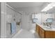 Bright bathroom featuring a glass enclosed shower, double sink vanity, and white cabinets for ample storage at 10404 Dapping Dr, Raleigh, NC 27614