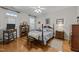 Bright bedroom with a four-poster bed, ceiling fan, and wood floors at 10404 Dapping Dr, Raleigh, NC 27614