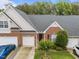 Charming brick townhome with a well-manicured lawn, colorful flower beds, and a two-car garage at 10404 Dapping Dr, Raleigh, NC 27614
