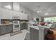 Bright kitchen features two-tone cabinets, stainless steel appliances, and a breakfast bar overlooking the living area at 10404 Dapping Dr, Raleigh, NC 27614