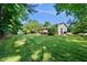 View of a spacious, grassy backyard with a shed, deck, and green home exterior at 105 Choyce Ct, Garner, NC 27529