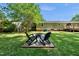 Backyard with green lawn, a fire pit, and two Adirondack chairs at 105 Choyce Ct, Garner, NC 27529
