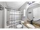 This bathroom features a tub with a geometric shower curtain and a round mirror above the vanity at 105 Choyce Ct, Garner, NC 27529