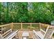 This wooden deck has classic white rocking chairs, a wooden railing, and backyard views at 105 Choyce Ct, Garner, NC 27529
