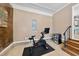 Home gym featuring modern exercise bike, tile flooring, and convenient beverage cooler at 105 Choyce Ct, Garner, NC 27529