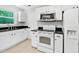Bright kitchen featuring white appliances, white cabinets and stainless microwave at 105 Choyce Ct, Garner, NC 27529