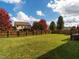 Expansive backyard with a well-maintained lawn, surrounded by a wooden fence and mature trees at 105 Pink Dogwood Ln, Mebane, NC 27302