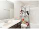 White bathroom features a vanity, toilet, and a shower/tub combo with a novelty shower curtain at 105 Pink Dogwood Ln, Mebane, NC 27302