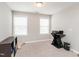 Well-lit bedroom with two windows, a ceiling light, desk, printer, filing cabinet, and plush carpet at 105 Pink Dogwood Ln, Mebane, NC 27302