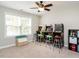 Bonus room with three arcade games, seating, ceiling fan, and a large window with natural light at 105 Pink Dogwood Ln, Mebane, NC 27302