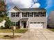 Charming two-story home with a well-manicured lawn, two-car garage, and inviting front porch at 105 Pink Dogwood Ln, Mebane, NC 27302