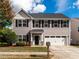 Charming two-story home with a manicured front yard, black shutters, and a two-car garage at 105 Pink Dogwood Ln, Mebane, NC 27302