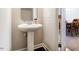 Half bath featuring pedestal sink, chrome faucet, with dining room out of focus in the background at 105 Pink Dogwood Ln, Mebane, NC 27302