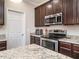 Kitchen with stainless appliances, granite counters, microwave, oven, and dark wood cabinetry at 105 Pink Dogwood Ln, Mebane, NC 27302