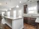 Bright kitchen with granite countertops, stainless steel appliances, and dark wood cabinetry at 105 Pink Dogwood Ln, Mebane, NC 27302