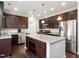 Well-lit kitchen with granite counters, stainless steel appliances, and dark wood cabinetry at 105 Pink Dogwood Ln, Mebane, NC 27302