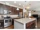 Open concept kitchen with stainless appliances, granite counters, and dark wood cabinetry at 105 Pink Dogwood Ln, Mebane, NC 27302