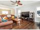 Spacious living room featuring wood floors, a ceiling fan, and comfortable brown sofas at 105 Pink Dogwood Ln, Mebane, NC 27302