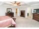 Spacious main bedroom with a tray ceiling, ceiling fan, carpet, and lots of natural light at 105 Pink Dogwood Ln, Mebane, NC 27302