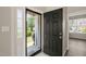 Welcoming entryway featuring a stylish black front door, sidelight window, and view of the front yard at 107 Meeting Hall Dr, Morrisville, NC 27560