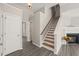 Bright hallway with hardwood floors, staircase, and access to multiple rooms, creating an open flow at 107 Meeting Hall Dr, Morrisville, NC 27560