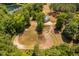 Picturesque aerial view of horse farm with pond, horse training area, and barn, set amidst lush greenery at 108 Cedarwood Dr, Louisburg, NC 27549