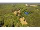 Aerial view of estate featuring lush woods, a pond, and a house with pool at 108 Cedarwood Dr, Louisburg, NC 27549