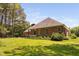 Brick house with a covered porch surrounded by green yard and natural landscaping at 108 Cedarwood Dr, Louisburg, NC 27549