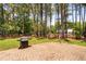 Large backyard with a brick paver patio, grill, and view of the surrounding woods at 108 Cedarwood Dr, Louisburg, NC 27549