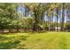 Lush backyard features mature trees and a fenced border, providing privacy and space at 108 Cedarwood Dr, Louisburg, NC 27549