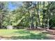 Relaxing backyard featuring a hammock, storage shed, lush trees, and a peaceful outdoor experience at 108 Cedarwood Dr, Louisburg, NC 27549