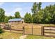 Exterior view of fenced paddock and horse barn with a blue metal roof at 108 Cedarwood Dr, Louisburg, NC 27549