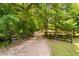 Wooded entrance to property with gated fence and gravel driveway at 108 Cedarwood Dr, Louisburg, NC 27549