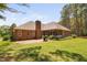 Back exterior of the brick home with covered patio and well-maintained lawn at 108 Cedarwood Dr, Louisburg, NC 27549