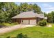 View of brick house with attached two-car garage and gravel driveway at 108 Cedarwood Dr, Louisburg, NC 27549