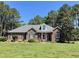 Inviting brick home with well-manicured lawn, mature trees, and charming architectural details at 108 Cedarwood Dr, Louisburg, NC 27549