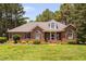Charming brick home with a well-manicured lawn and mature trees, showcasing its inviting curb appeal at 108 Cedarwood Dr, Louisburg, NC 27549