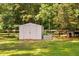Utility shed and dog house sit behind a wood fence in a grassy yard at 108 Cedarwood Dr, Louisburg, NC 27549