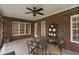Relaxing patio with a ceiling fan, brick accent wall, and stylish outdoor furniture, perfect for entertaining or enjoying the outdoors at 108 Cedarwood Dr, Louisburg, NC 27549