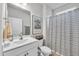 Clean and functional bathroom with a white vanity, mirror, and a shower with a striped curtain at 1096 Aberlour Ln, Burlington, NC 27215