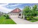 Charming home featuring a tan exterior, attached garage, manicured lawn, and a welcoming front porch at 1096 Aberlour Ln, Burlington, NC 27215