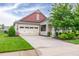 Charming home featuring a tan exterior, attached garage, manicured lawn, and a welcoming front porch at 1096 Aberlour Ln, Burlington, NC 27215