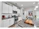 Bright kitchen features white cabinets, stainless steel appliances and a center island with granite countertops at 1096 Aberlour Ln, Burlington, NC 27215