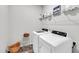 Well-lit laundry room with modern appliances, wire shelving, and decorative baskets at 1096 Aberlour Ln, Burlington, NC 27215