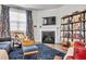 Cozy living room with a fireplace, television, bookshelves, and patterned armchairs at 1096 Aberlour Ln, Burlington, NC 27215
