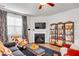 Comfortable living room with a fireplace, bookshelves, television, and large window at 1096 Aberlour Ln, Burlington, NC 27215
