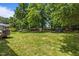 Large, grassy backyard with mature trees and partial fencing, ideal for outdoor activities at 110 Fairchild Downs Pl, Cary, NC 27518